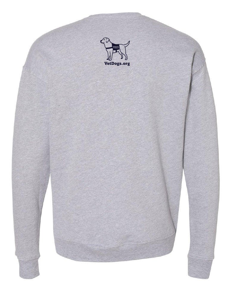 This photo show a view of the back of the grey long sleeved crew neck sweatshirt. There is a navy blue image of a dog on the center top of the shirt. the dog is wearing a service dog vest. below the image of the dog is text that says, "VetDogs.org"