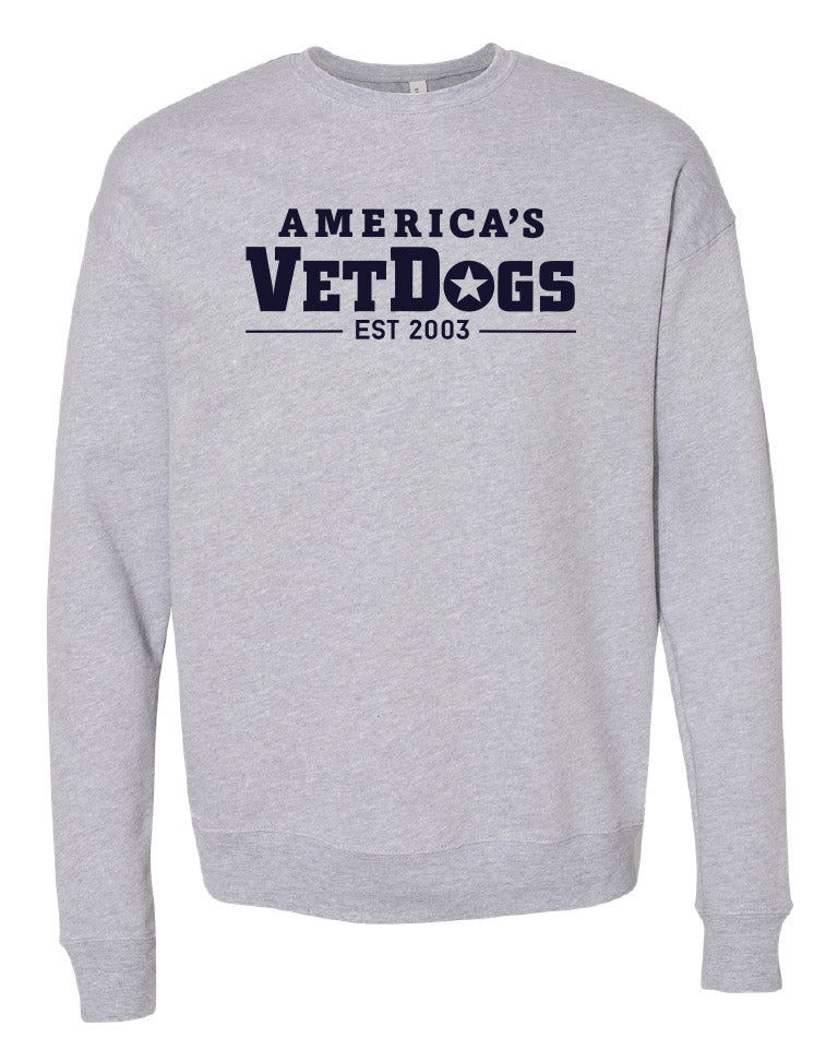 Front facing photo of a long sleeved grey crew neck sweatshirt. The shirt as a fitted bottom. The shirt has fitted wrists. The front of the shirt says "America's VetDogs EST. 2003" in Navy Blue lettering